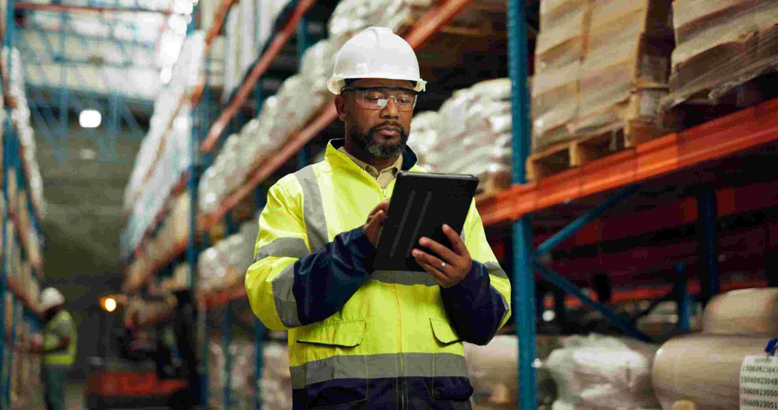 Black man, helmet and tablet at warehouse for distribution industry