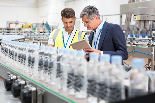 assembly line employee inspecting the quality of the water bottles