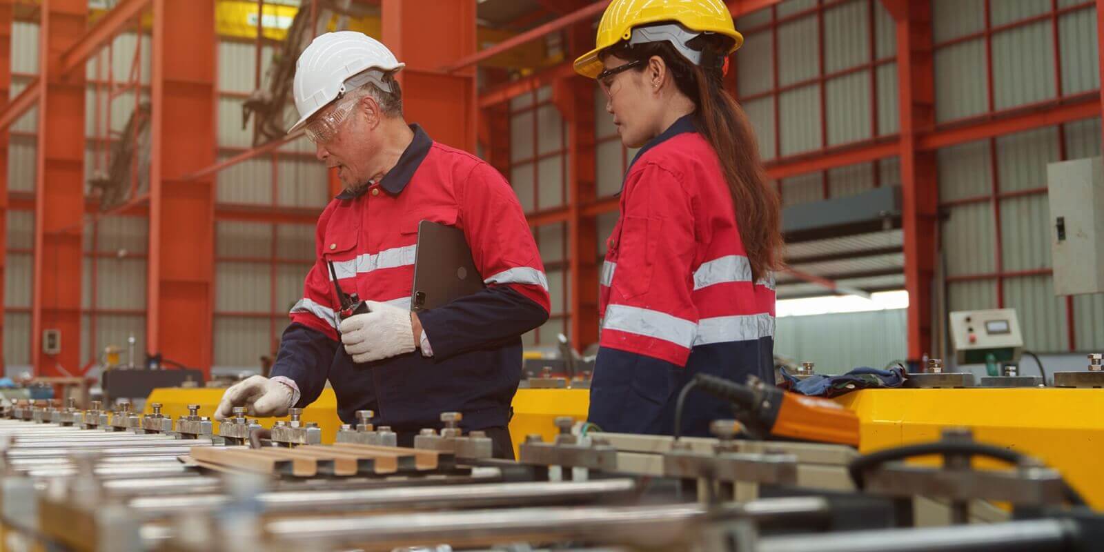 engineers and staff inspect the production line of components in a metal sheet and metal roofing manufacturing plant
