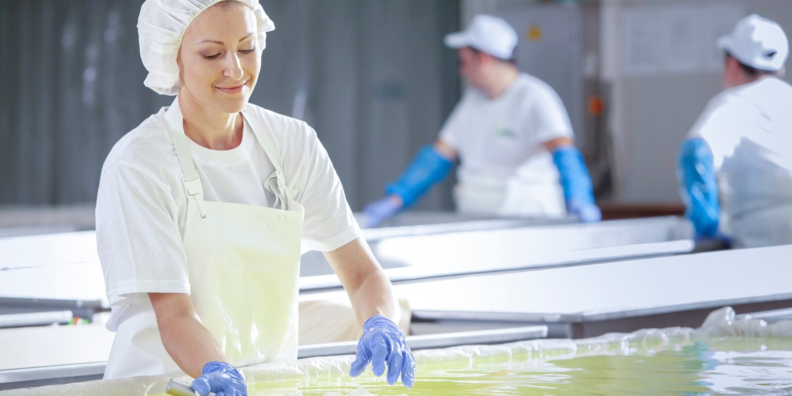 female worker on white feta cheese production line in an industrial factory