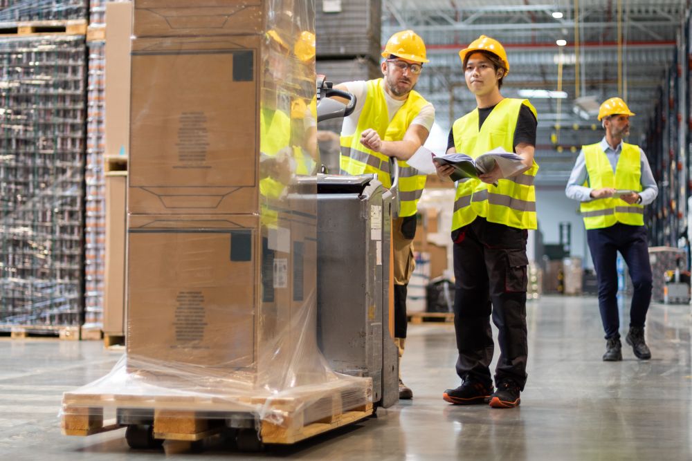 trained warehouse team pushing forward a heavy pallet of high cost inventory